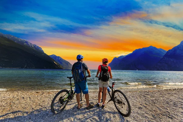 Hegyi kerékpározás, pár biciklivel, napnyugtakor a Garda-tó, Riva — Stock Fotó
