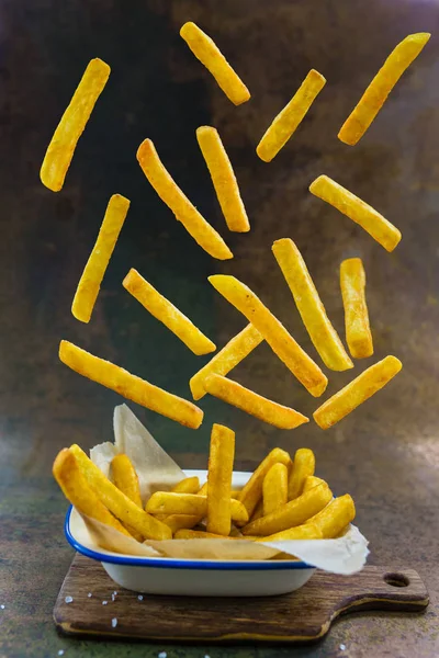 Homemade crispy Potato Fries with grain Salt flying ingredients. — Stock Photo, Image