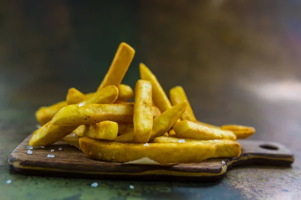 Domowe chrupiące ziemniaki frytki z ziarna soli. Usmażyć pyszne snac — Zdjęcie stockowe