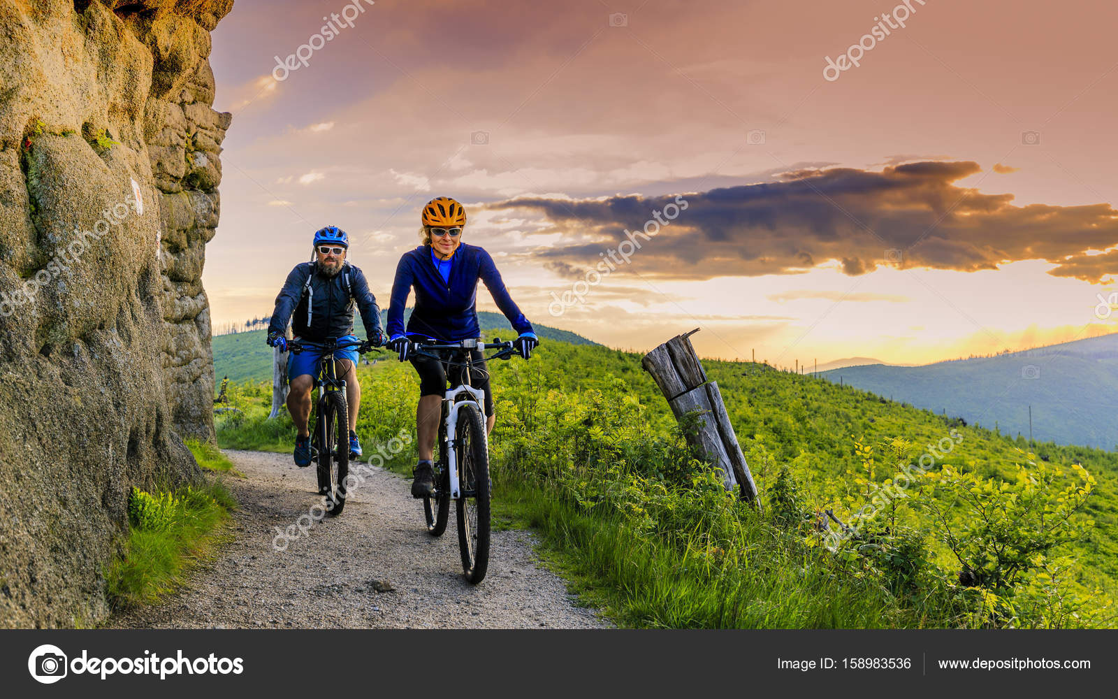 Mountain bike donne e uomo in sella a biciclette al tramonto