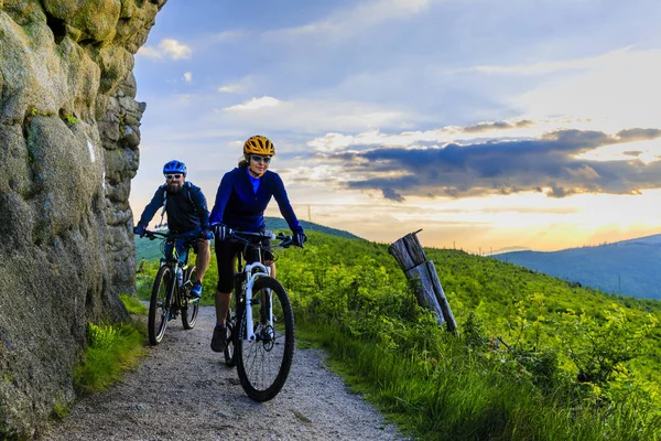 Hegyi kerékpáros nő és férfi naplemente Mountain Bikes lovaglás — Stock Fotó