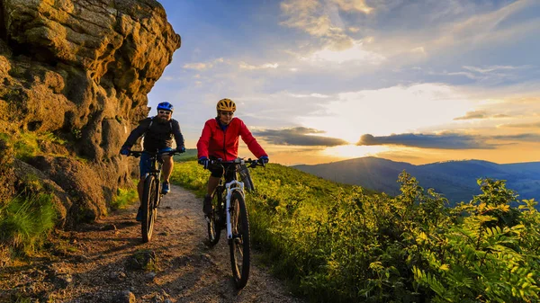 Hegyi kerékpáros nő és férfi naplemente Mountain Bikes lovaglás — Stock Fotó