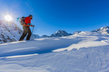 Güneş tepeye tırmanma snowshoeing kış dağlarda uzun yürüyüşe çıkan kimse