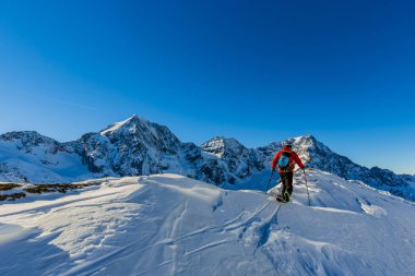 Dağcı backcountry Kayak ile karlı bir sırt boyunca yürüyüş 