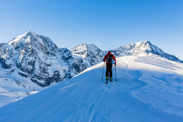 Dağcı backcountry Kayak ile karlı bir sırt boyunca yürüyüş 