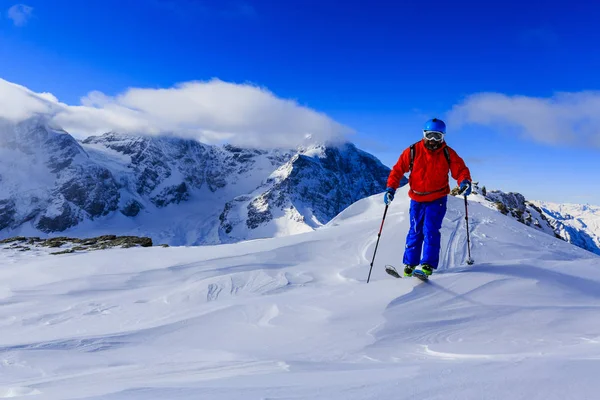 Mountaineer backcountry ski walking up along a snowy ridge with — Stock Photo, Image