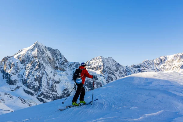 Esquí de montaña backcountry caminar a lo largo de una cresta nevada con —  Fotos de Stock