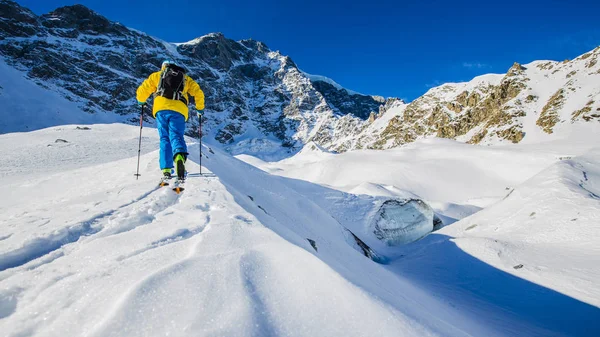 Alpiniste ski de fond marchant le long d'une crête enneigée avec — Photo