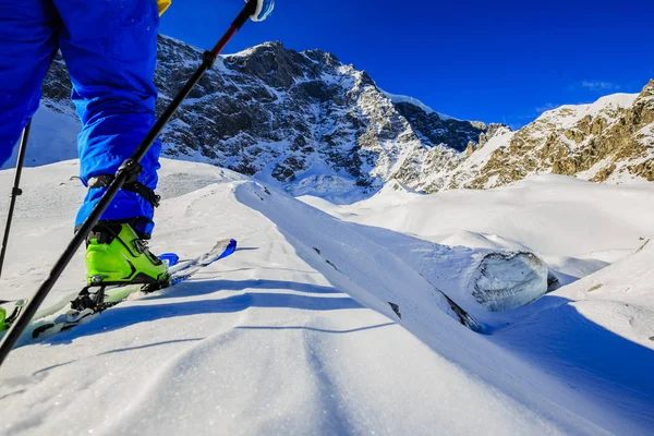 Mountaineer backcountry ski gå upp längs en snöig bergskam med — Stockfoto