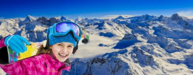 Kayakçı genç kayaklar ile karlı bir sırt boyunca. Arka planda mavi