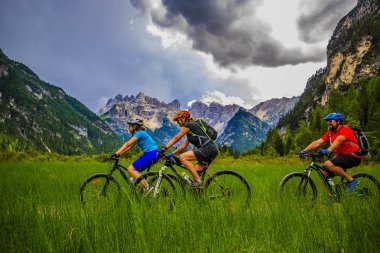 Mountain biking family with bikes on track, Cortina d'Ampezzo, D clipart