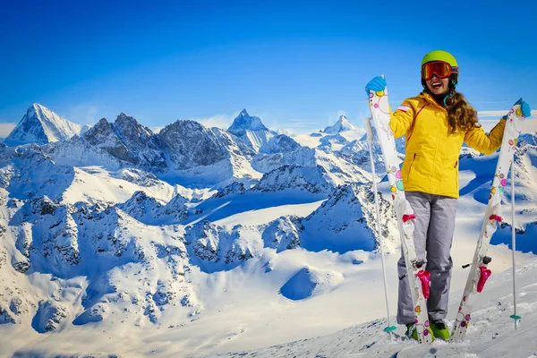 Skier teenager along a snowy ridge with skis. In background blue — Stock Photo, Image