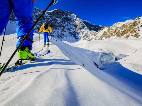 Mountaineer backcountry ski walking up along a snowy ridge with — Stock Photo, Image