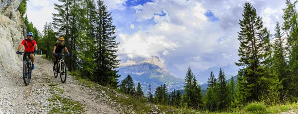 Mountain biking couple with bikes on track, Cortina d\'Ampezzo, D