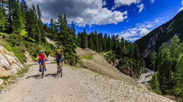 Mountain biking woman and young girl along river in Dolomites, I — Stock Photo, Image