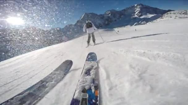 Bergbeklimmer skiën langs een besneeuwde bergkam. In de achtergrond blauw bewolkte hemel en glanzende zon en Tre Cime, Drei Zinnen in Zuid-Tirol, Dolomieten, Italië. Extreme wintersport avontuur. — Stockvideo
