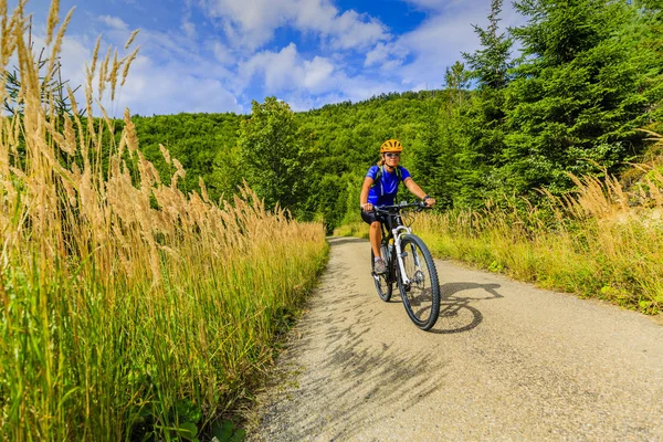 Bisiklete binme, dağ bikeing kadın sonbahar ormandaki döngüsü izinde. — Stok fotoğraf