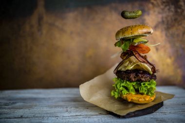 Hamburger gerçekçi uçan malzemelerle. Lezzetli füme ızgara