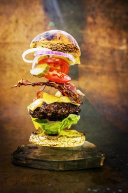 Hamburger gerçekçi uçan malzemelerle. Lezzetli füme ızgara