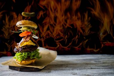 Hamburger gerçekçi uçan malzemelerle. Lezzetli füme ızgara