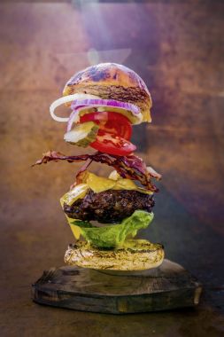 Hamburger gerçekçi uçan malzemelerle. Lezzetli füme ızgara