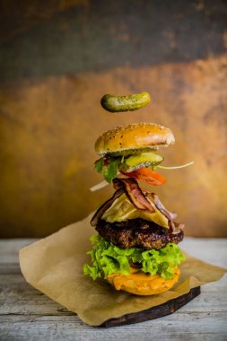 Hamburger gerçekçi uçan malzemelerle. Lezzetli füme ızgara