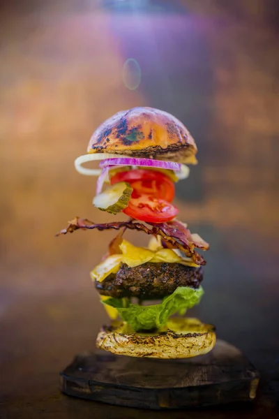 Hamburger con ingredienti volanti realistici. Gustosa griglia affumicata — Foto Stock