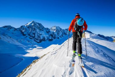 Dağcı backcountry Kayak ile karlı bir sırt boyunca yürüyüş 
