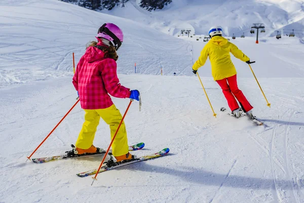 Mujer esquiando con su hija en la nieve en un día soleado en el mountai —  Fotos de Stock