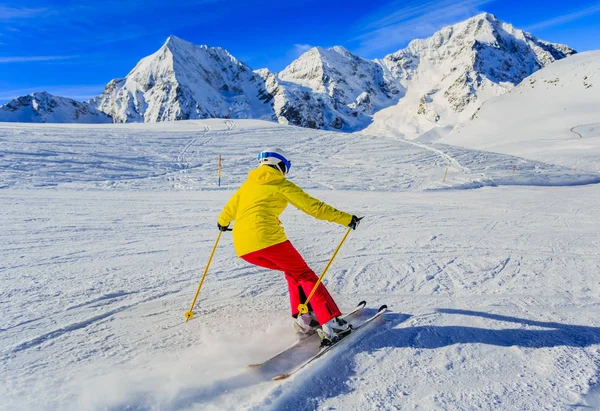 Mujer esquiando en la nieve en un día soleado en las montañas. Esquí en ganar —  Fotos de Stock