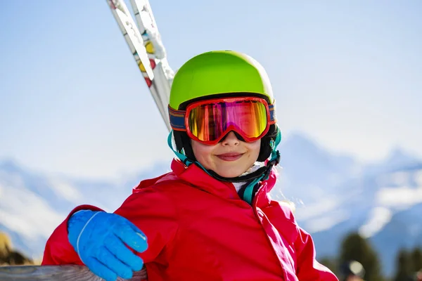 Porträt eines glücklichen jungen Mädchens, das mit Ski im Schnee sitzt und gewinnt — Stockfoto