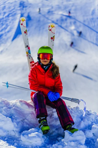 快乐的年轻女孩的画像坐在雪地里与滑雪在 wi — 图库照片