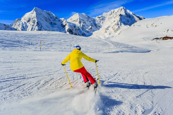 Kobieta na nartach po śniegu w słoneczny dzień w górach. Narty, win — Zdjęcie stockowe