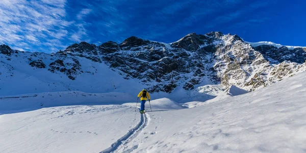 Esquí de montaña backcountry caminar a lo largo de una cresta nevada con —  Fotos de Stock