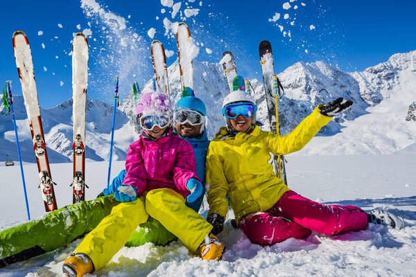 Happy family enjoying winter vacations in mountains. Playing wit