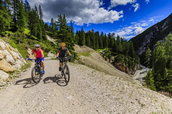 山の自転車に乗る女性と少女は、ドロミテの川に沿って私 — ストック写真