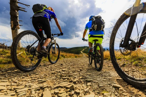 Mountain cykling kvinnor och man rider på cyklar vid solnedgången mountain — Stockfoto