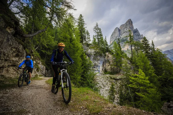 Mountain biking couple with bikes on track, Cortina d\'Ampezzo, D