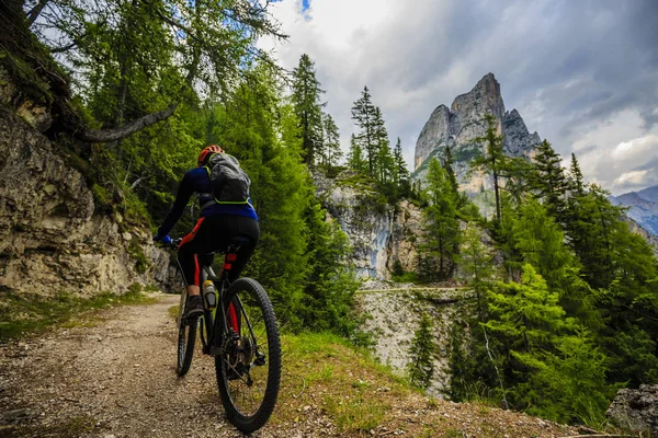 Tourist cycling in Cortina d'Ampezzo, stunning rocky mountains o — Stock Photo, Image