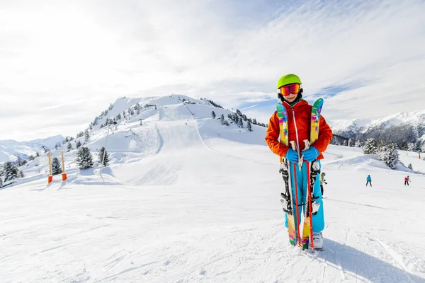 Портрет счастливой молодой девушки, сидящей в снегу с лыжами в победе — стоковое фото