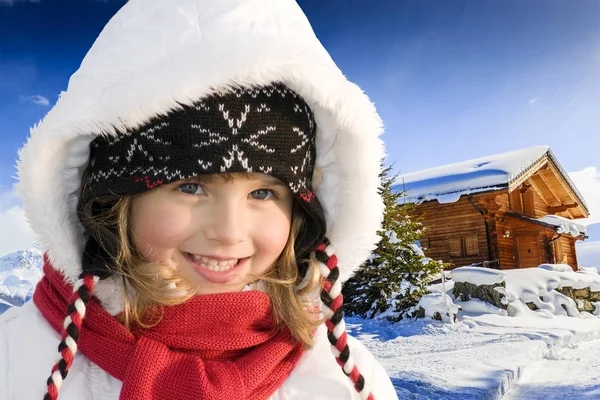 Portrett av lykkelig ung jente som sitter i snøen med ski i seire – stockfoto