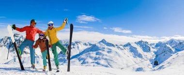 Dağlarda kış tatillerinin tadını çıkaran mutlu aile, Val Thorens