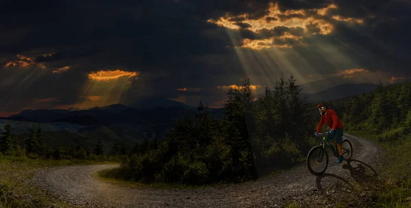 Jízda na kole muže na koni na kole při západu slunce hory lesní krajina. — Stock fotografie