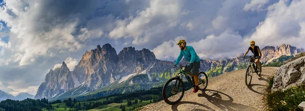 Ciclismo mulher e homem andando de bicicleta em Dolomites montanhas e — Fotografia de Stock