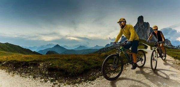 Ciclismo mulher e homem andando de bicicleta em Dolomites montanhas e — Fotografia de Stock