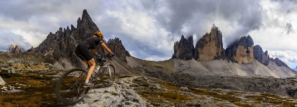 Tourist cycling in Cortina d'Ampezzo, stunning rocky mountains o — Stock Photo, Image