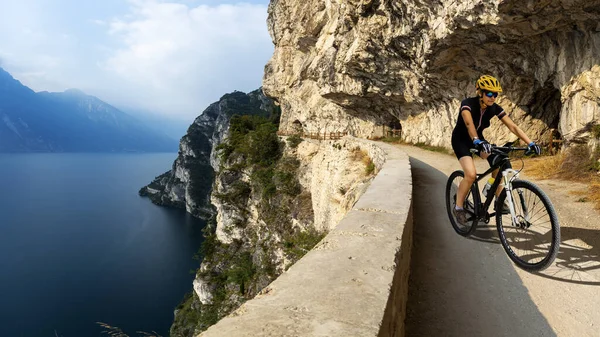 Hombre ciclista a caballo en bicicleta en las montañas del amanecer y el lago de Garda l —  Fotos de Stock