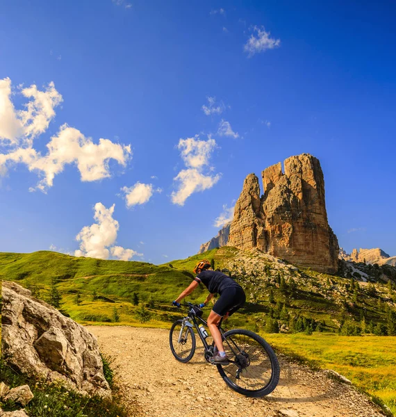 Tourist cycling in Cortina d'Ampezzo, stunning rocky mountains o — Stock Photo, Image