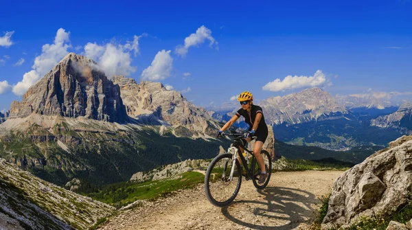 Tourist cycling in Cortina d'Ampezzo, stunning rocky mountains o — Stock Photo, Image