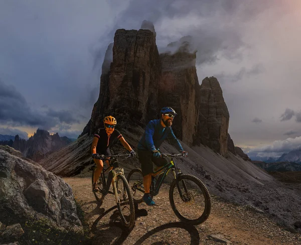 Couple cycling on electric bike, rides mountain trail. Woman and — Stock Photo, Image